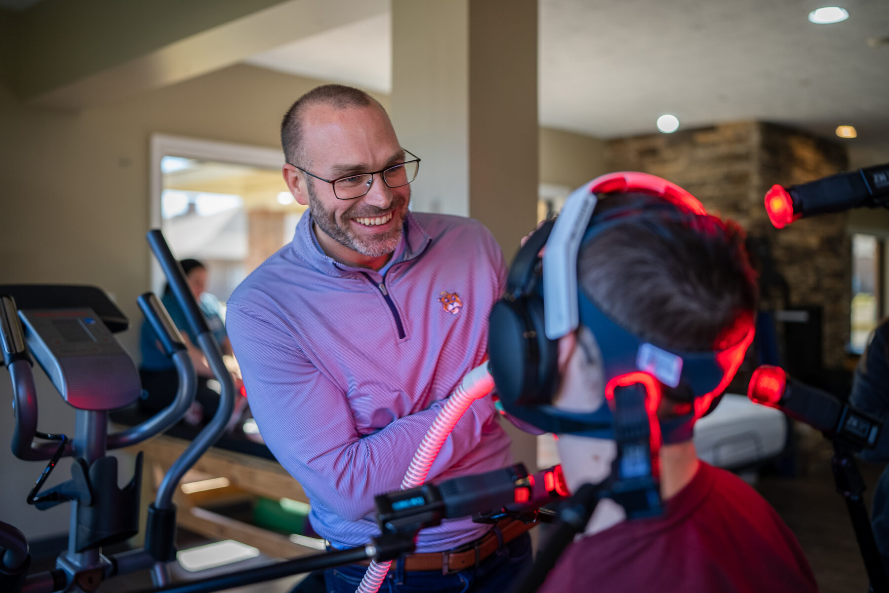Dr. Kyle Daigle smiling with a young patient during a red-light therapy session at a NeuroSage Center.